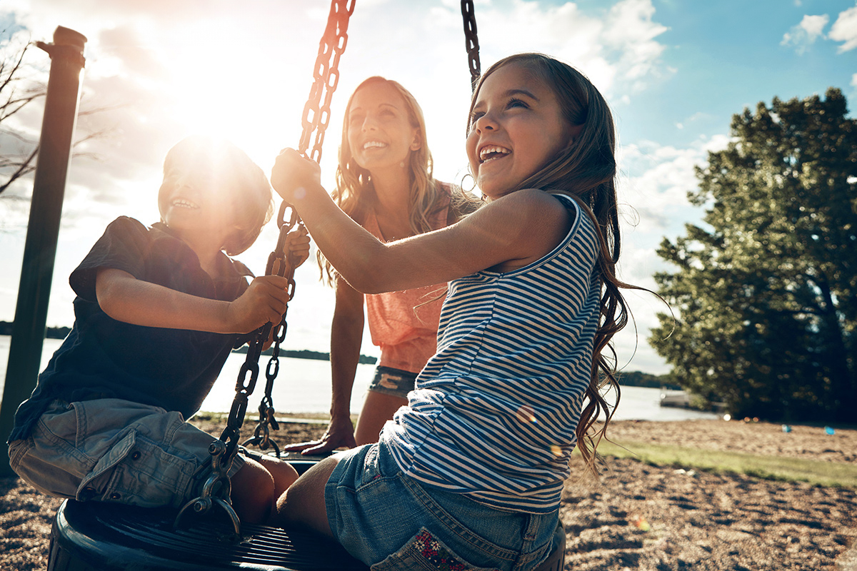 mom with children on tire swing