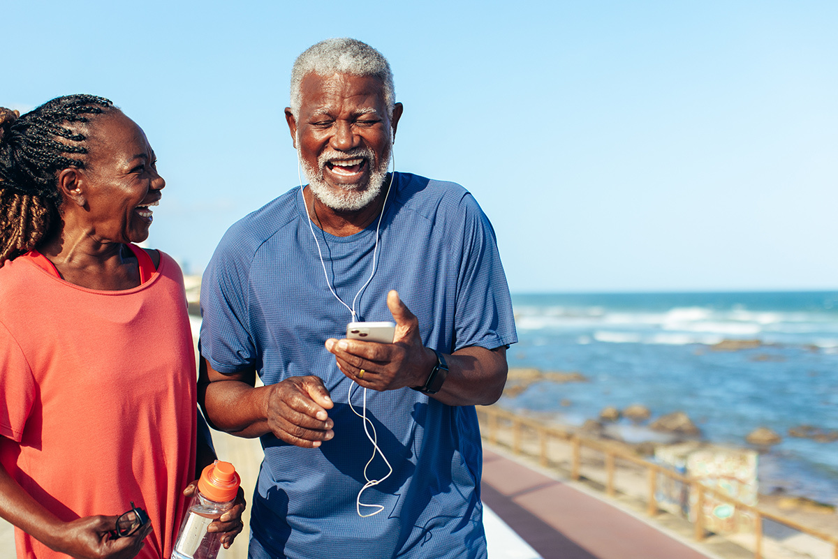 retired couple laughing by ocean